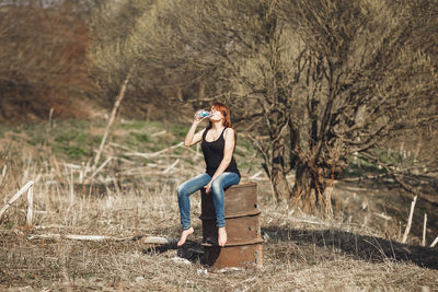 Full length of woman sitting on field