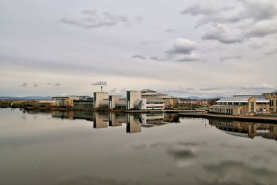 Reflection of buildings in lake against sky