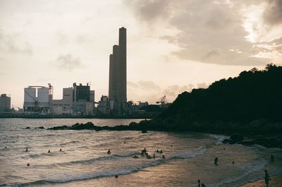 Scenic view of sea by buildings against sky