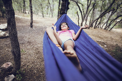 Girl lying on hammock in forest