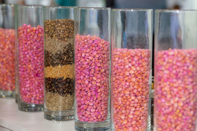 Corn seeds in a glass flask with red pesticide. corn in transparent flasks at the exhibition.