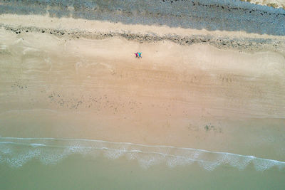 Aerial view of couple lying at beach