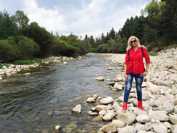 Full length of woman standing by stream