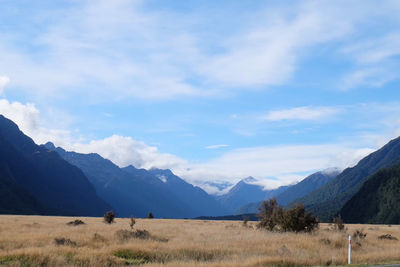 Scenic view of field and mountains against sky