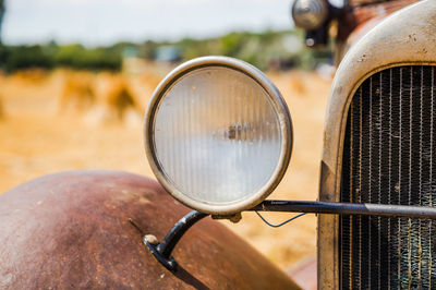 Headlight or headlamp on a vintage car in a western landscape.