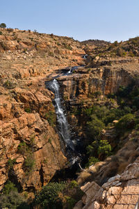 Scenic view of waterfall against sky