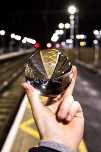 Cropped image of hand holding crystal ball on road