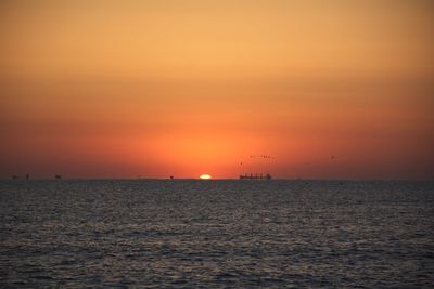 Scenic view of sea against romantic sky at sunset