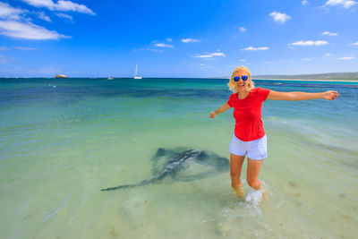 Woman with arms outstretched standing in sea