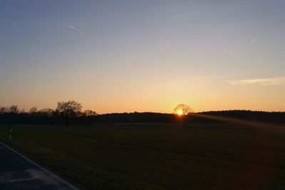 Scenic view of field against clear sky during sunset