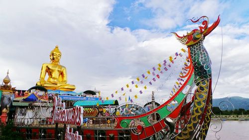 Carousel against cloudy sky