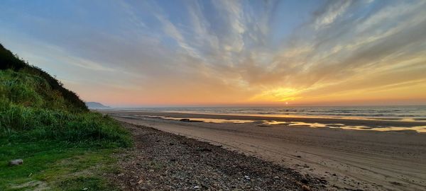 Scenic view of beach against sky during sunset