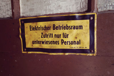 Close-up of yellow text on brick wall