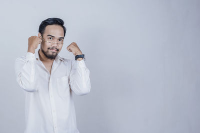 Young man standing against white background