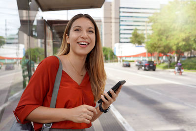 Young woman in the city waiting for a bus or taxi