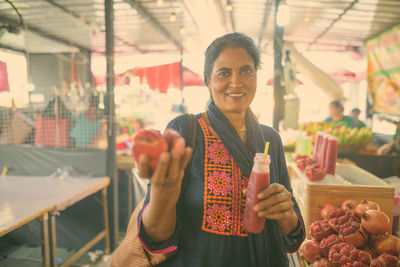 Portrait of smiling woman holding fruit