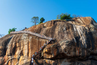 Low angle view of rock formations against clear blue sky