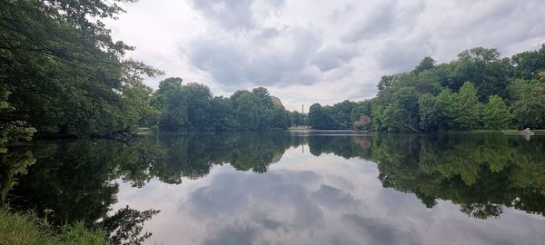 Scenic view of lake by trees against sky