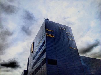 Low angle view of modern building against cloudy sky