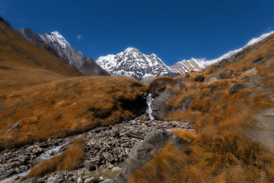 Scenic view of snowcapped mountains against blue sky