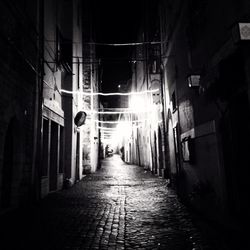 Narrow walkway in city at night