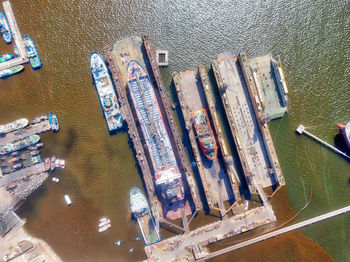 High angle view of container ships at harbor on sunny day