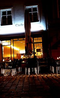 Tables and chairs in street at night