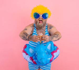 Portrait of man wearing sunglasses against pink background