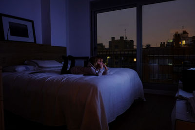 Girl lying on bed at home during night