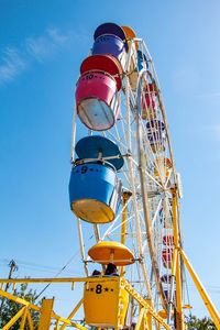 Low angle view of ferris wheel against blue sky