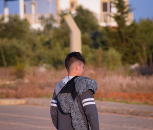 Rear view of boy standing on road