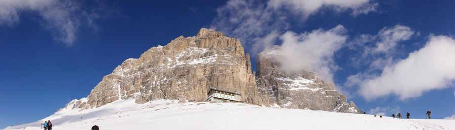 Scenic view of snow covered mountain against blue sky