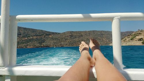 Low section of woman relaxing in boat on sea