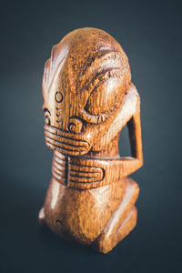 Close-up of figurine on table against black background