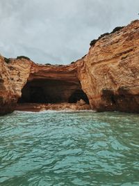 Rock formations by sea against sky