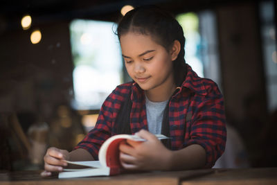 Portrait of a smiling young woman sitting at restaurant