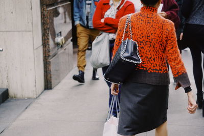 Low section of people standing on sidewalk