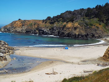 Scenic view of beach against clear blue sky