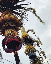 Low angle view of ferris wheel against cloudy sky