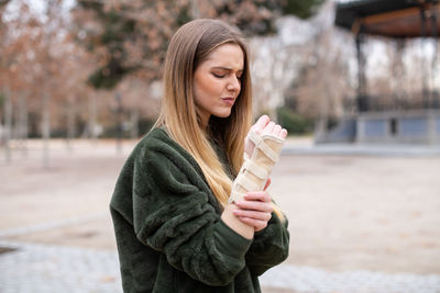 Young woman with fractured hand standing on street