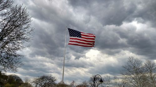 Low angle view of american flag against cloudy sky