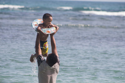 Father carrying son in sea