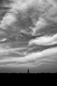 Silhouette man standing on field against sky