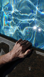 Low section of person swimming in pool