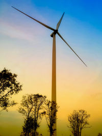 Low angle view of wind turbine against sky during sunset