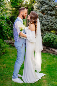 Full length of couple standing against trees