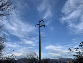 Low angle view of electricity pylon against sky