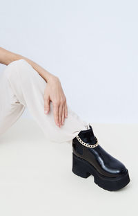 Low section of woman sitting on floor against white background