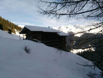 Houses on snow covered landscape against sky
