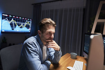 Young man using mobile phone while sitting at home